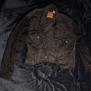 Black jean jacket with soft sweatshirt material sleeves.